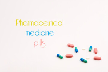 multicolored tablets and capsules lie in a white background. inscription Pharmaceutical medicine...