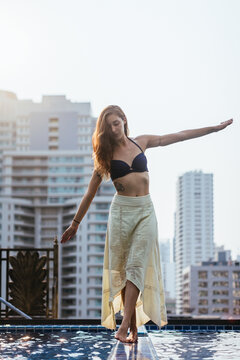 Beautiful woman walking on the edge of the pool