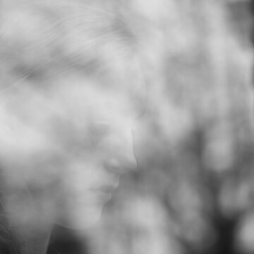 Face of a young woman behing reflecting window glass