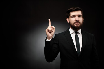 Man in suit pointing his index finger up