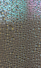 Many colorful little bubbles on the glass surface close-up