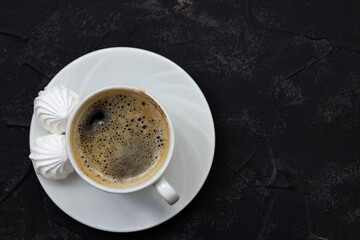  Minimalistic white cup of coffee on black background, top view