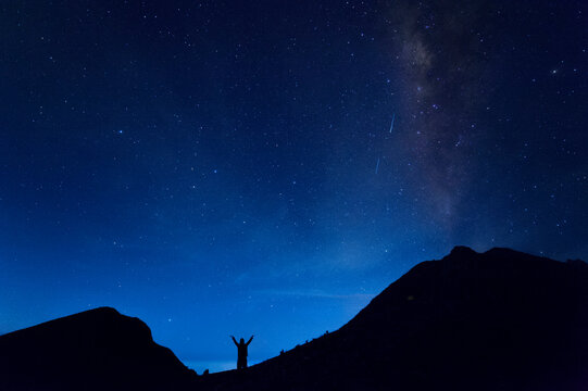 A man standing between to mountain tops