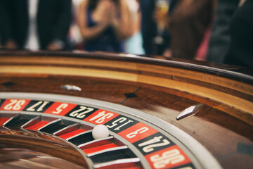 Casino: Ball Rests In 15 Slot In Roulette With Crowd Behind