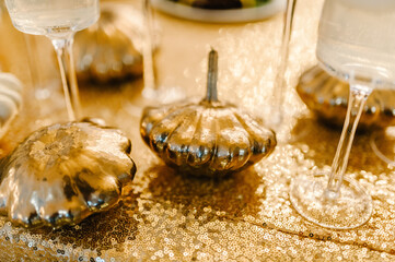 Decorated table for wedding. Candles, autumn leaves, confetti, pumpkins. Autumn location and Halloween decor. Setting.