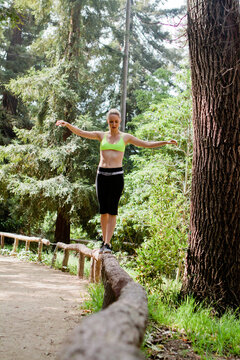 Woman Balancing on a Wooden Fence.