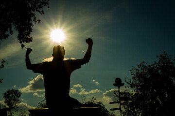 Silhouette of a man with hands raised. Received power from god