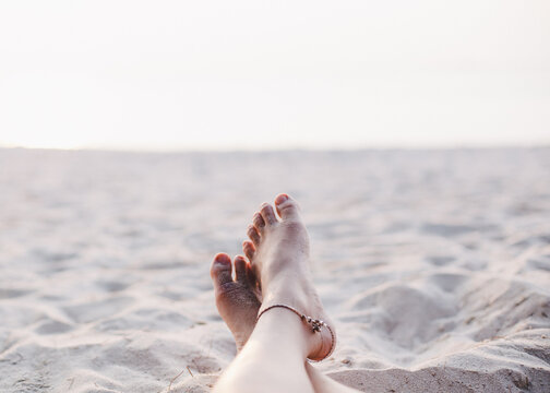 Woman bare feet enjoying the sunset on the beach