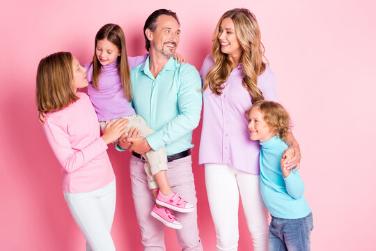 Photo positive dream big family enjoy together spend time daddy hold younger daughter mommy care cuddle support offsprings wear casual style outfit isolated pink color background