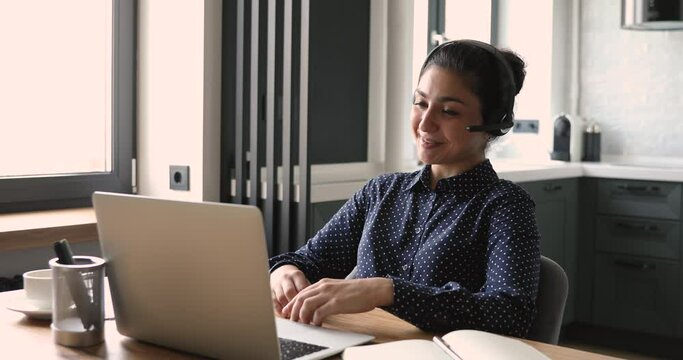 Indian businesswoman working from home office wear headset talks use video call application. Negotiation remotely due corona virus or covid-19 self-isolation, modern tech easy convenient usage concept