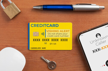 Vishing (voice phishing) concept, a credit card on a table next to a lock a key and a smartphone...