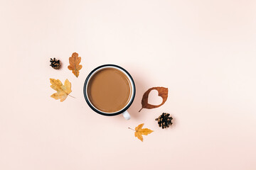 Creative autumn flat lay overhead top view coffee milk latte cup, pine cones, dried leaves on millennial beige background copy space minimal style. Fall season template for feminine blog social media