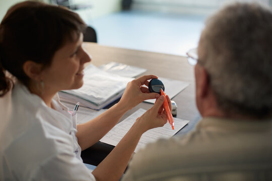 Female physiotherapist giving pedometer device instructions to a patient