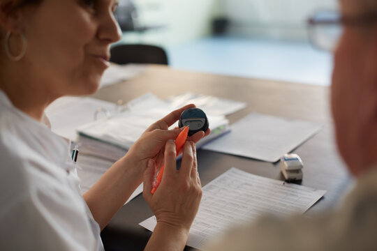 Physiotherapist giving pedometer device instructions to a patient