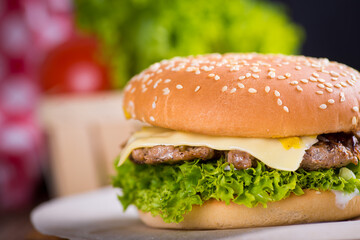 juicy burgers with a red napkin and fries on a black wooden background