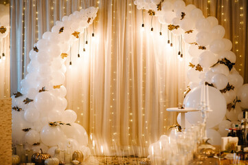 Decorated arch for wedding ceremony. White balloons, candles, autumn leaves and small pumpkins....
