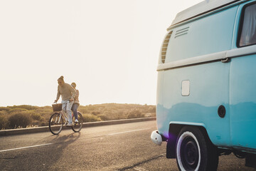 Active old senior people couple enjoy together the bike - mature man carry his wife and enjoy the outdoor leisure activity in happines - elderly joy lifestyle and travel concept with blue van  © simona