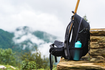 Backpack with water bottle on stone fence
