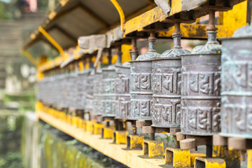 Fototapeta na wymiar Picture of buddhist prayer wheels in a row