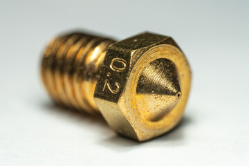 Macro Photo of  a Single 0.2mm brass 3D printer nozzle on an iscolated background.