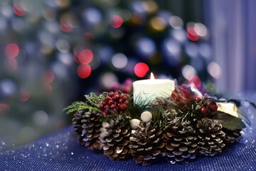 Christmas and New Year wreath and tree lights. Cozy holiday atmosphere at home.
