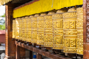 Picture of buddhist prayer wheels in a row