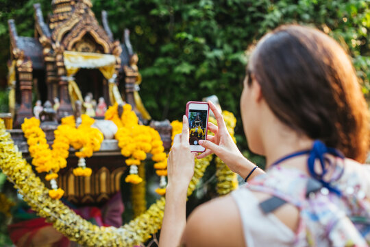 Beautiful woman taking pictures with smartphone in the city