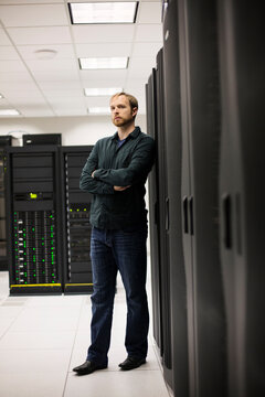 Young IT engineer standing near datacenter servers