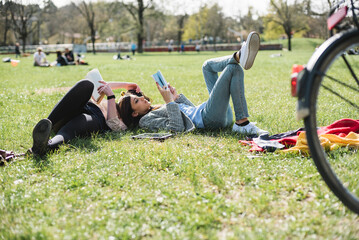 Young women studying lying in the park