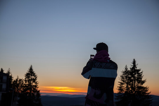 Young man taking a photo in the mountain