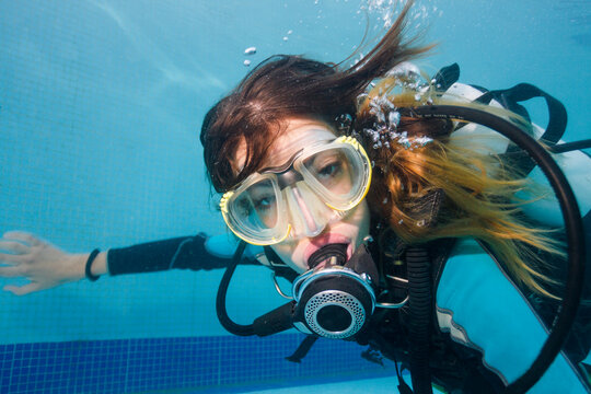 Portrait of a beautiful woman scuba diving underwater in the swimming pool