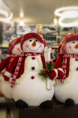 Big cheerful snowman in a red jacket with skis. Christmas decoration puppet snowman. Winter, christmas and new year symbol