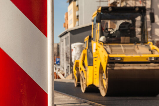 Works on new road with heavy machinery.