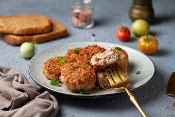 Meat cutlets on a gray plate with a fork, rip