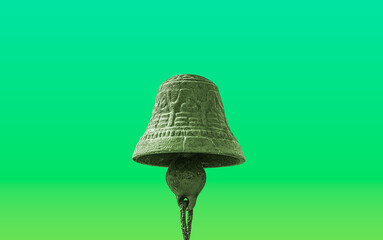 Freigestellte Glocke aus Metall vor grünem Hintergrund mit Verlauf