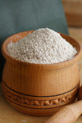 Shelled and ground almond nuts in wooden bowl.