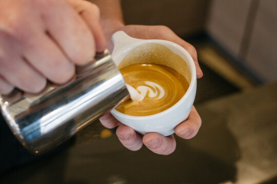 pouring latte cappuccino coffee, in cafe