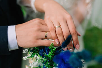 Obraz na płótnie Canvas bride and groom holding hands with rings