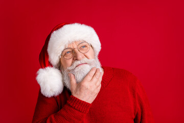 Close up portrait of unsure pensive old man in santa claus headwear look copyspace touch hand chin think x-mas newyear gifts wear shine sweater isolated bright color background