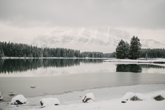 Winter mountain and forest reflection on calm lake water at Two Jack Lake in Banff National Park
