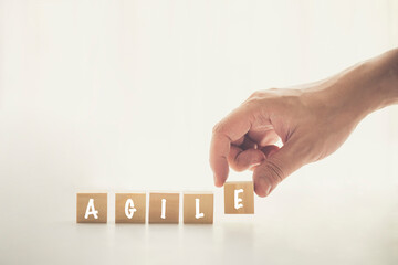 Agile and Scrum in Software Development concepts, Hand pick wooden cube and place with text to fill the word AGILE. Brochure design template, card, banner with copy space for label text.