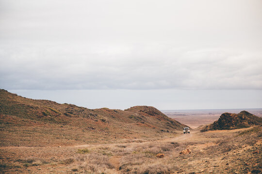 Car driving in a steppe trail