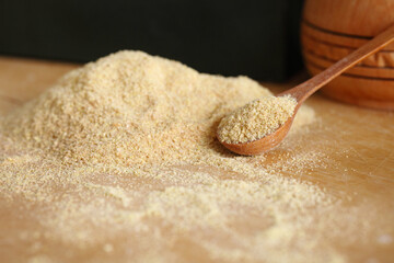 Whole and ground brown flax seeds or linseeds on wooden spoon