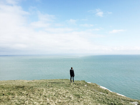 Rear view of a girl looking out across the cliffs of Dover, UK