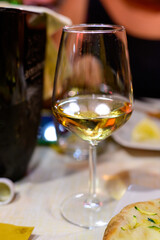 Glass of cold dry white wine served outdoor in cafe at night in Italy
