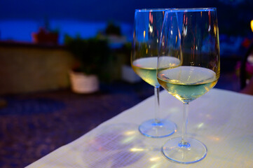 Two glasses of cold dry white wine served outdoor in cafe at night in Italy