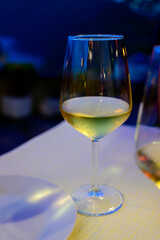 Glass of cold dry white wine served outdoor in cafe at night in Italy