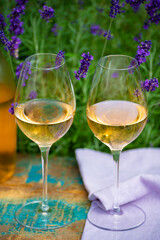 Love Provence, romantic picnic with glasses of cold French rose wine and purple lavender flowers in sunny summer garden