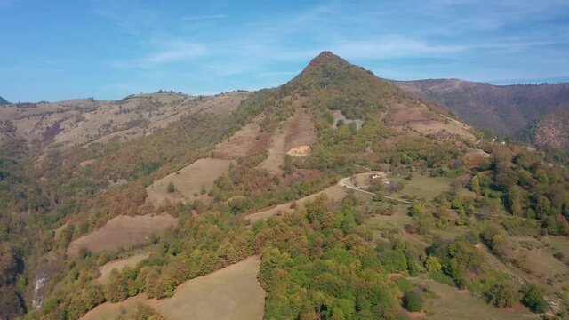 Drone flight over an autumn mountain with peaks, meadows and colorful forests, Balkan mountains, Bulgaria