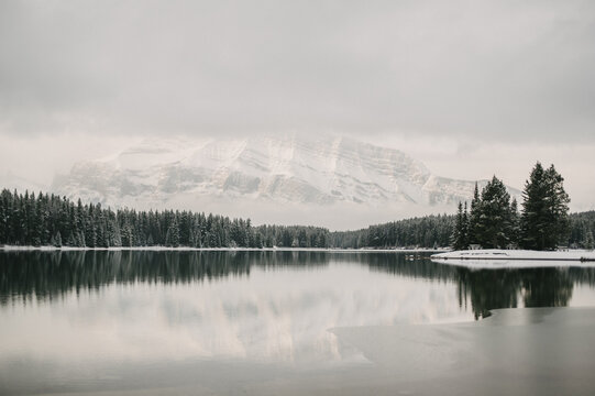 Winter mountain and forest reflection on calm lake water at Two Jack Lake in Banff National Park